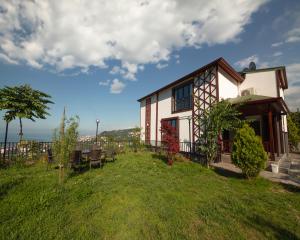 uma casa numa colina com um jardim verde em STONE VILLAGE em Trabzon