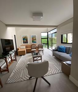 uma sala de estar com um sofá e uma cadeira em Aconchegante Casa 3 suites no Atiradores em Joinville