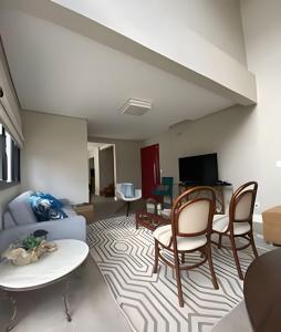 uma sala de estar com um sofá e cadeiras em Aconchegante Casa 3 suites no Atiradores em Joinville