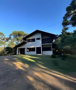 a white house with a black roof at CURTA! | Casa dos Pássaros - Campo Alegre in Campo Alegre