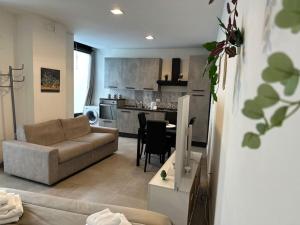 a living room with a couch and a kitchen at Lucrezia’s home A in Catania