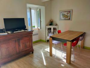 a living room with a table and a television at Maison cosy avec jardin, centre de Sauzon, 200m du port, 3 chambres, WiFi, terrasse et barbecue - FR-1-418-211 in Sauzon