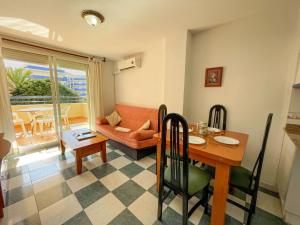 ein Wohnzimmer mit einem Tisch und einem Sofa in der Unterkunft Apartamentos Bonaire 3000 in Oropesa del Mar