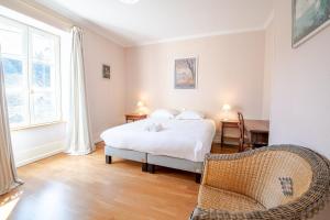 a bedroom with a bed and a table and a chair at Le Clos des Tilleuls - Gîte 10 personnes in Francueil
