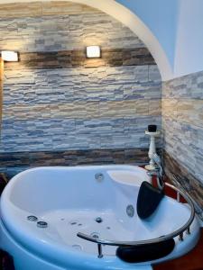uma banheira na casa de banho com uma parede de pedra em City Center Brabus Jacuzzi Lux em Belgrado