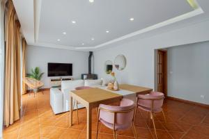 a living room with a table and a couch at Casa Rosa in Quinta do Conde