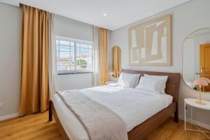 a bedroom with a large bed and a window at Casa Rosa in Quinta do Conde