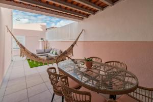 um pátio com uma rede de descanso, uma mesa e cadeiras em Casa Rosa em Quinta do Conde