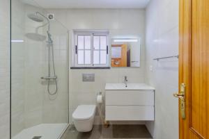 a bathroom with a toilet and a sink and a shower at Casa Rosa in Quinta do Conde