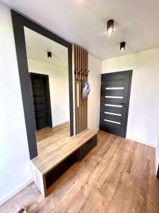 Zimmer mit großem Spiegel und Holzboden in der Unterkunft Luxury Apartments in Malý Slavkov