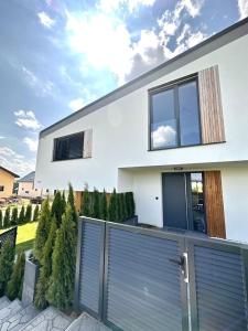 une maison blanche avec une porte de garage bleue dans l'établissement Luxury Apartments, à Malý Slavkov