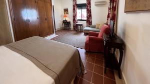 a bedroom with a bed and a couch in a room at Hotel Sindhura in Vejer de la Frontera