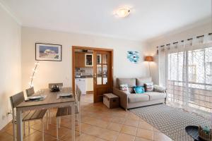 a living room with a table and a couch at Quinta da Gomeira 60 in Tavira