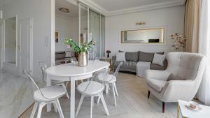 una sala de estar blanca con mesa blanca y sillas en Lion Apartments - The Palace premium apartment with Old City & River View en Gdansk