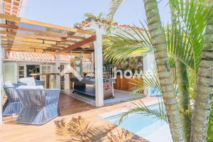 un patio con una parrilla y una palmera en Casa com piscina a 100m da praia em Búzios, en Búzios