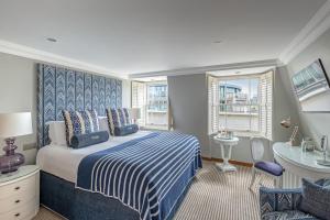 a bedroom with a blue and white bed and a window at Harbour Hotel & Spa Christchurch in Christchurch