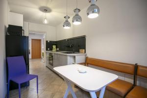 a kitchen with a white table and purple chairs at The House Stiller Grund in Hohenfließ