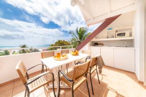 a kitchen and dining room with a table and chairs at Résidence Pierre & Vacances Premium Les Tamarins in Sainte-Anne