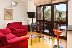 ein Wohnzimmer mit einem roten Sofa und einem Tisch in der Unterkunft Hotel Recostano Residence in Trevignano Romano