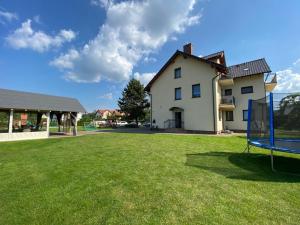 a yard with a basketball hoop in front of a house at Willa JANTAR in Dębki