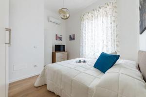 um quarto branco com uma grande cama branca e uma almofada azul em [Careggi/Mayer] comfortable apart em Florença