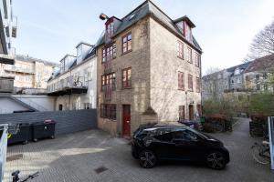 a black car parked in front of a building at aday - Apartment suite 1 Aalborg Center in Aalborg