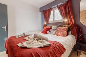 Schlafzimmer mit einem großen Bett und roten Vorhängen in der Unterkunft Magnifique appartement avec vue sur les montagnes in Crans-Montana