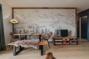 Cette chambre comprend un bureau et un mur orné d'une fresque murale représentant la montagne. dans l'établissement Magnifique appartement avec vue sur les montagnes, à Crans-Montana