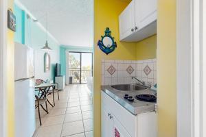 a kitchen with a sink and a refrigerator at Pirates Bay A210 in Fort Walton Beach