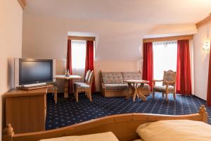 une chambre d'hôtel avec un lit et une télévision dans l'établissement Landhaus Alte Scheune, à Francfort-sur-le-Main