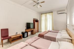 una camera d'albergo con due letti e una TV a schermo piatto di Hotel Altavilla 9 a Roma