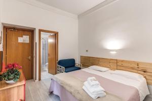 a bedroom with a large bed and a blue chair at Hotel Altavilla 9 in Rome