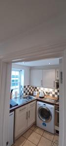 a kitchen with a sink and a washing machine at The Court Cottage 2 bedroom in Exeter
