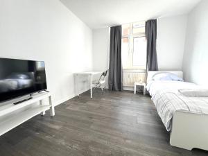 een slaapkamer met een bed en een flatscreen-tv bij Unterkunft mit Einzelzimmer Zentrum in Neumünster
