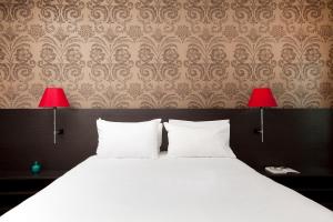 メスにあるレジドーム メス ロレーヌのベッドルーム1室(白いベッド1台、赤いランプ2つ付)