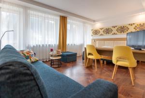 uma sala de estar com um sofá azul e uma mesa com cadeiras amarelas em Ryterski em Rytro