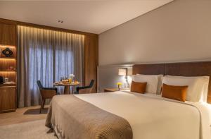 una camera d'albergo con un grande letto e un tavolo di L'Hotel PortoBay São Paulo a San Paolo
