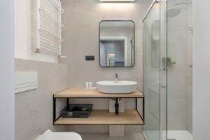 a bathroom with a sink and a mirror at Modern Studios in the Centre of Poznań by Renters in Poznań
