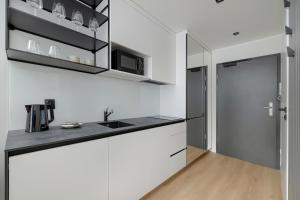 a kitchen with white cabinets and a sink at Modern Studios in the Centre of Poznań by Noclegi Renters in Poznań