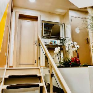 Una escalera en una habitación con una puerta y flores en Elegancia del JJM, en Annemasse