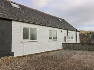 a white house with windows on the side of it at Rockview Barn in Dufftown