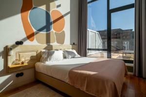 a bedroom with a bed and a large window at Limehome Porto Rua da Conceicao in Porto