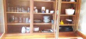 un armario de madera lleno de platos y platos en Gîte Studio Saint Ribert, en La Rochette