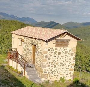 un pequeño edificio de piedra con escaleras en una montaña en Gîte Studio Saint Ribert, en La Rochette