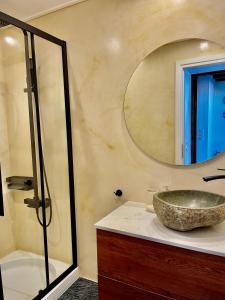 Erietta Suites في مدينة خانيا: حمام مع حوض حجري ومرآة