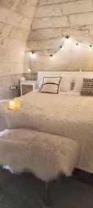 una camera da letto con un grande letto con lenzuola e cuscini bianchi di Palazzo Emy a Lecce