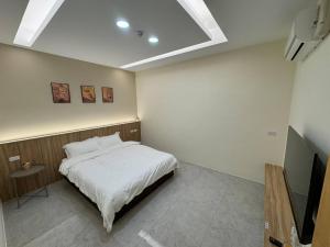 a bedroom with a bed and a flat screen tv at 包棟陌上花加賴詢問優惠moshang446電麻烤肉switch in Hualien City