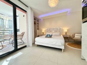 um quarto branco com uma cama e uma varanda em Magnifique studio bohème neuf cœur de ville em Antibes