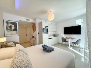 アンティーブにあるMagnifique studio bohème neuf cœur de villeの白いベッドルーム(大型ベッド1台付)、キッチンが備わります。