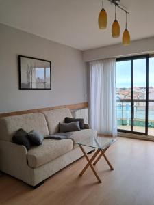 sala de estar con sofá y mesa de cristal en Le Sylvania en Saint-Georges-de-Didonne